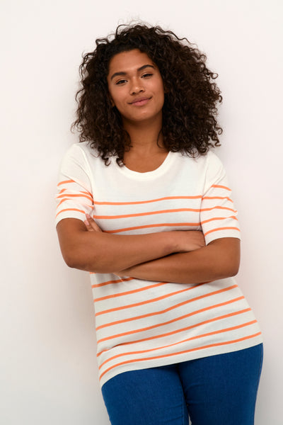 Billede af modellen med den hvide t-shirt med tynde orange striber. Modellen står med armene over kors. 